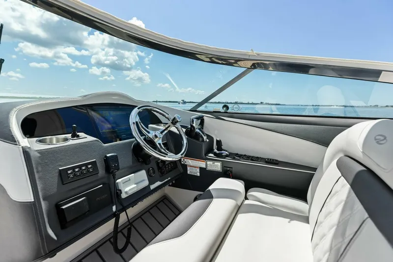  Yacht Photos Pics 2022 Regal 33 OBX boat interior with steering wheel and dashboard, overlooking the water.