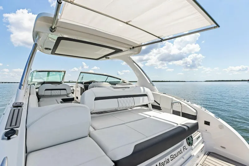  Yacht Photos Pics 2022 Regal 33 OBX luxury boat interior with spacious seating and canopy on calm water.