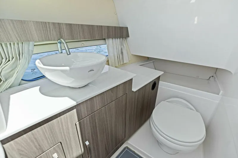  Yacht Photos Pics Luxurious bathroom interior of 2022 Regal 33 OBX boat with modern sink and toilet.