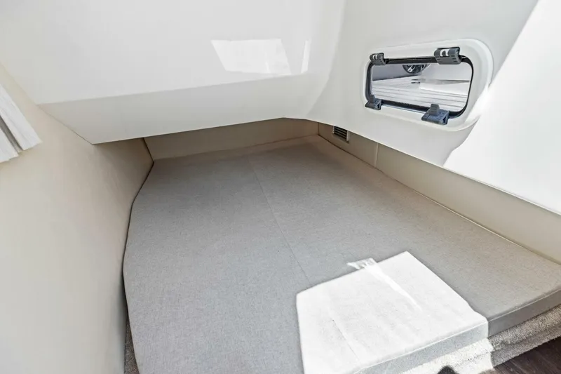  Yacht Photos Pics 2022 Regal 33 OBX cabin interior with window and cushioned sleeping area.