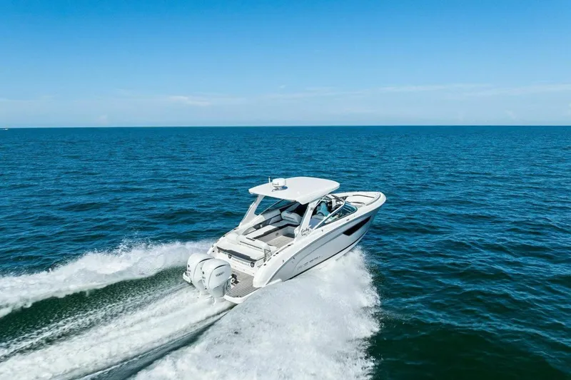  Yacht Photos Pics 2022 Regal 33 OBX boat cruising on open ocean under clear blue sky.