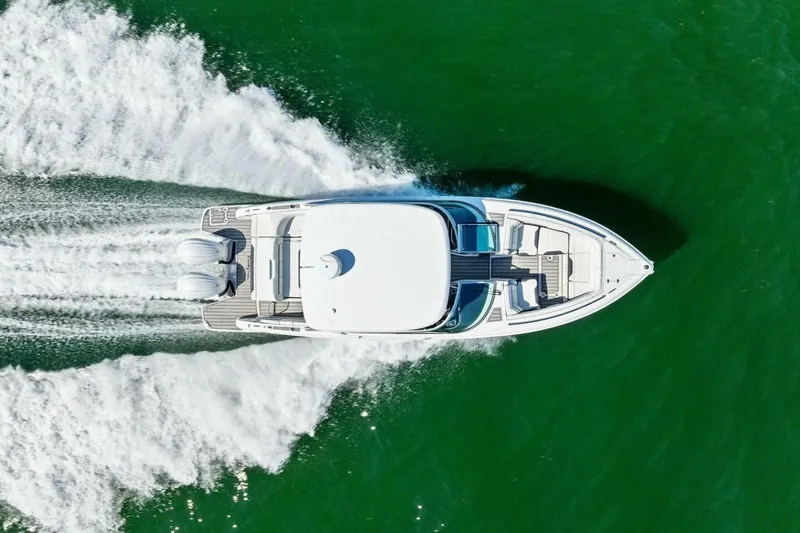  Yacht Photos Pics Aerial view of 2022 Regal 33 OBX boat cruising on green water.