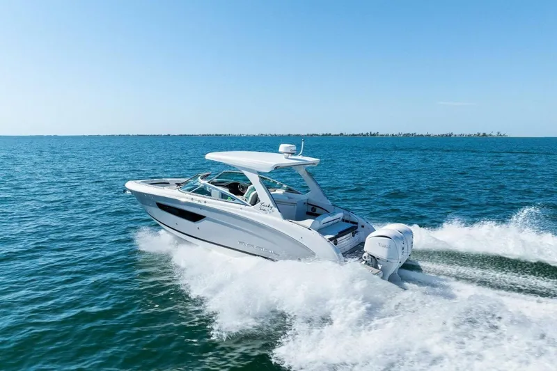  Yacht Photos Pics 2022 Regal 33 OBX boat cruising on open water under clear blue sky.