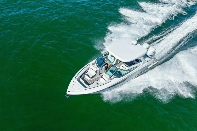  Yacht Photos Pics 2022 Regal 33 OBX boat cruising on open water, aerial view.