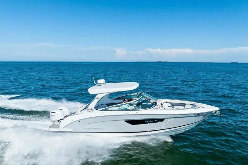  Yacht Photos Pics 2022 Regal 33 OBX boat cruising on open blue water under clear sky.
