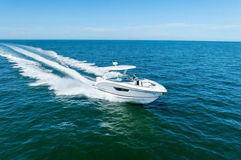  Yacht Photos Pics 2022 Regal 33 OBX boat cruising on open blue ocean waters.