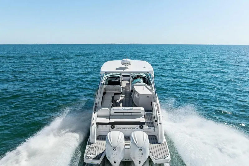  Yacht Photos Pics 2022 Regal 33 OBX boat cruising on open sea, rear view.