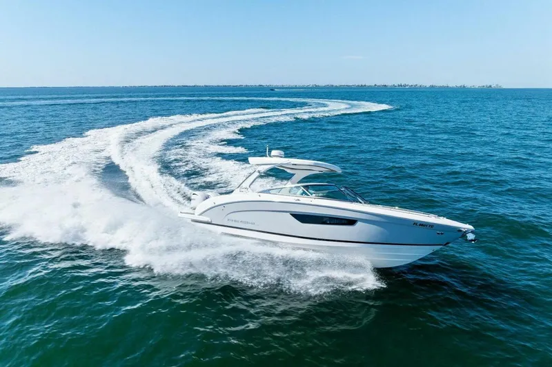  Yacht Photos Pics 2022 Regal 33 OBX boat cruising swiftly on open blue water.