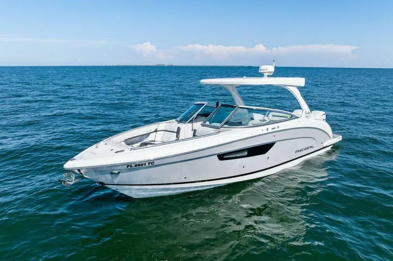  Yacht Photos Pics 2022 Regal 33 OBX boat cruising on open water under clear blue skies.