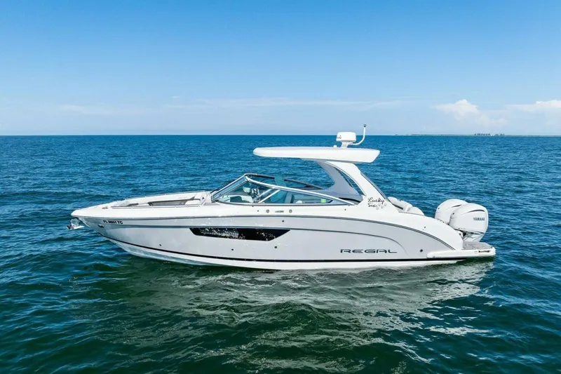  Yacht Photos Pics 2022 Regal 33 OBX boat cruising on open water under clear blue skies.