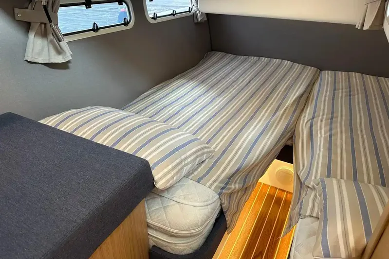 Bertie Yacht Photos Pics 2024 Nimbus 405 Coupé cabin with striped bedding and wooden flooring.