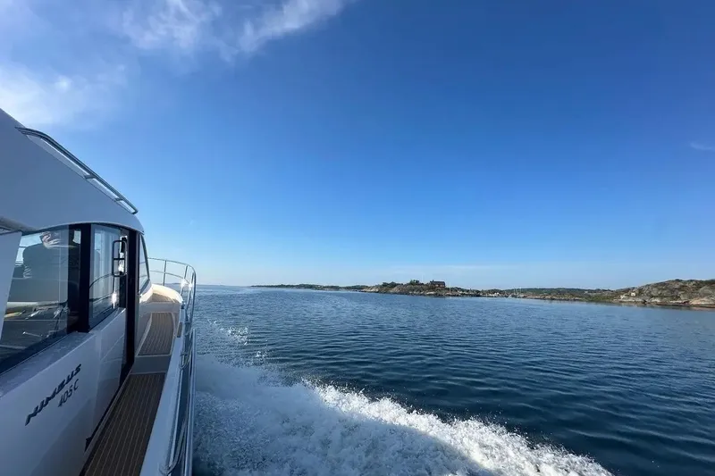 Bertie Yacht Photos Pics 2024 Nimbus 405 Coupé cruising on a serene blue sea under a clear sky.