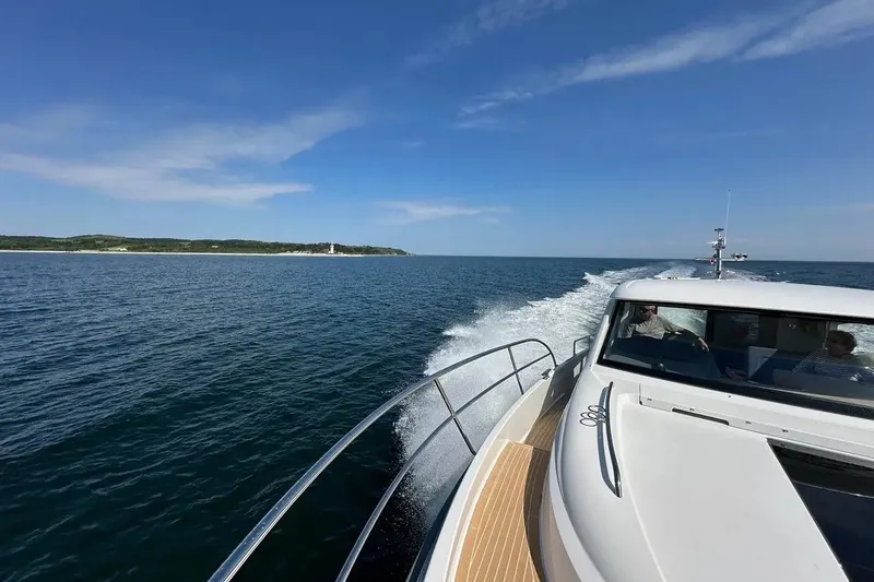 Bertie Yacht Photos Pics Nimbus 405 Coupé 2024 cruising on open water under clear blue skies.