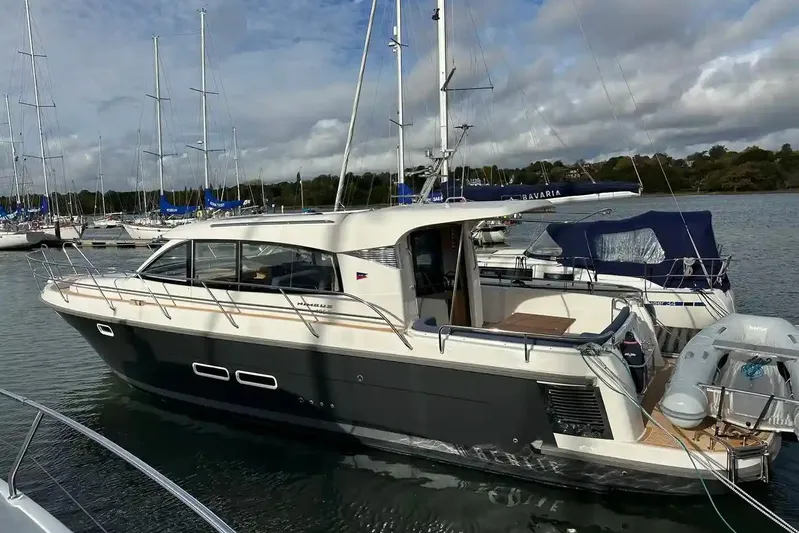 Bertie Yacht Photos Pics 2024 Nimbus 405 Coupé yacht docked in a marina, surrounded by sailboats.