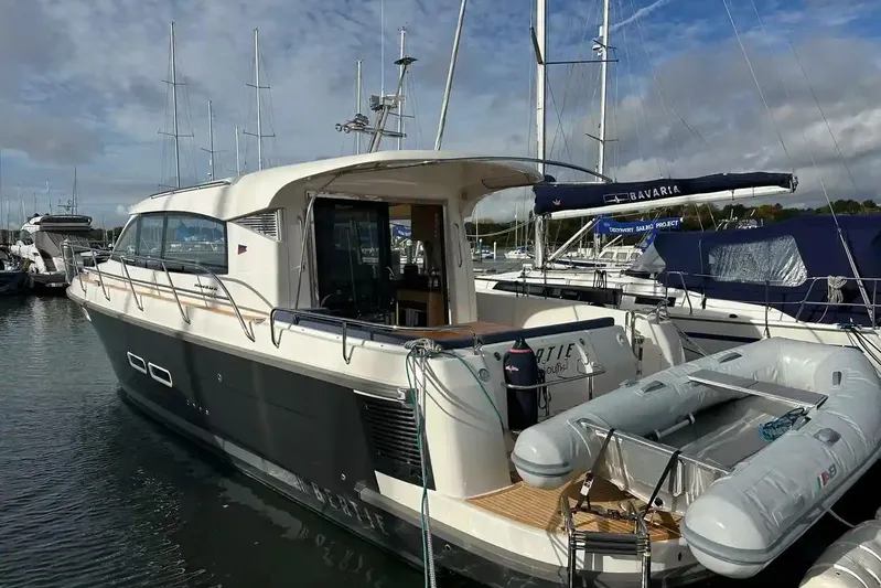 Bertie Yacht Photos Pics 2024 Nimbus 405 Coupé yacht docked at marina, featuring sleek design and inflatable dinghy.