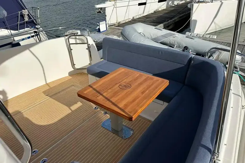 Bertie Yacht Photos Pics Luxurious seating area on 2024 Nimbus 405 Coupé yacht with wooden table and blue cushions.