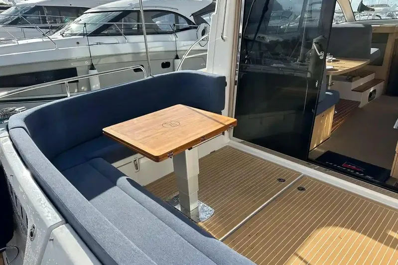 Bertie Yacht Photos Pics 2024 Nimbus 405 Coupé yacht interior with cozy seating and wooden table.