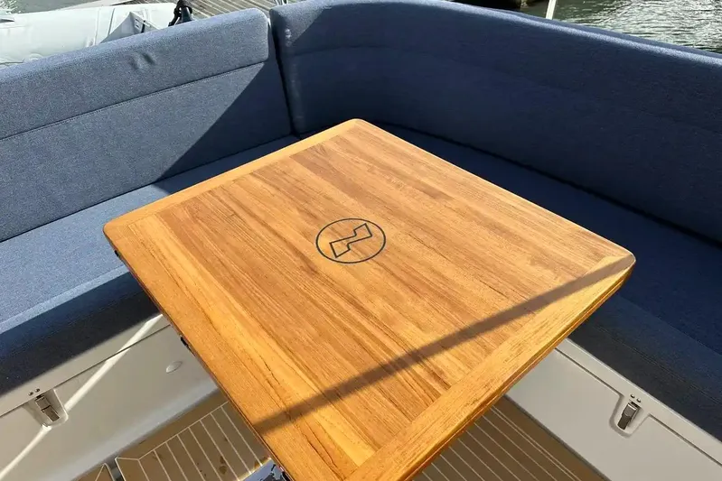Bertie Yacht Photos Pics Teak table and blue seating on 2024 Nimbus 405 Coupé boat deck.
