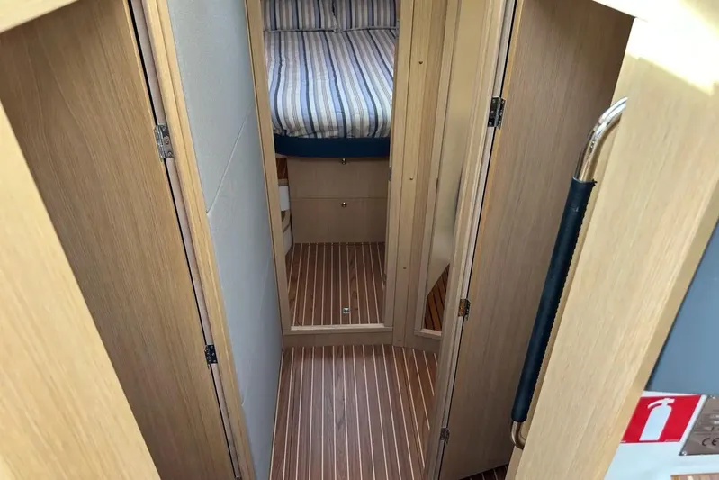 Bertie Yacht Photos Pics 2024 Nimbus 405 Coupé interior with wooden flooring and striped bedding.