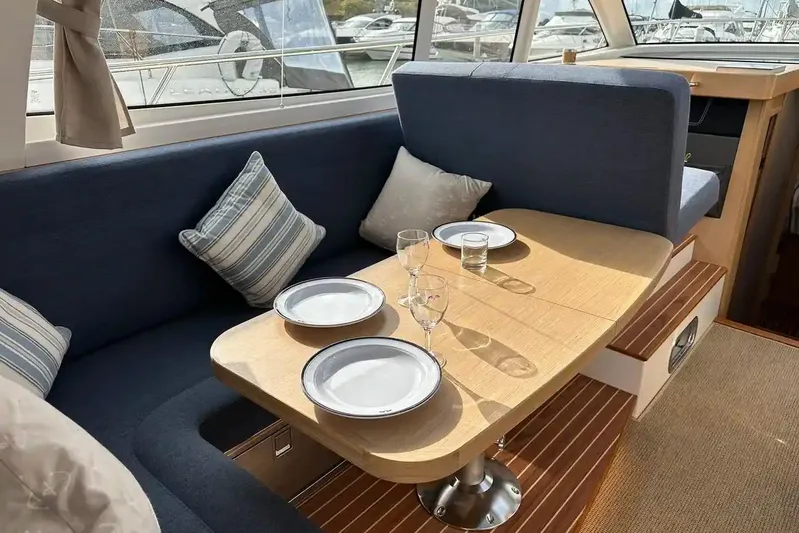 Bertie Yacht Photos Pics Interior of 2024 Nimbus 405 Coupé with dining area, set table, and comfortable seating.