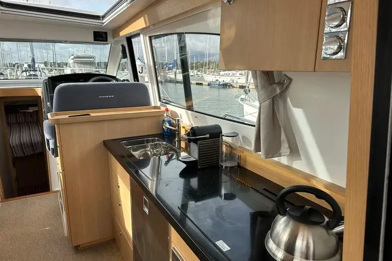 Bertie Yacht Photos Pics Interior of 2024 Nimbus 405 Coupé yacht with modern kitchen and scenic marina view.