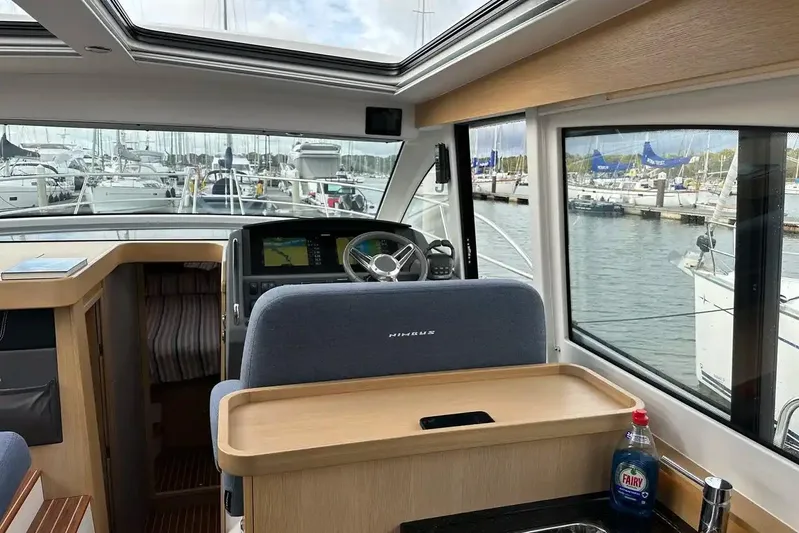 Bertie Yacht Photos Pics Interior view of 2024 Nimbus 405 Coupé yacht cockpit with marina background.