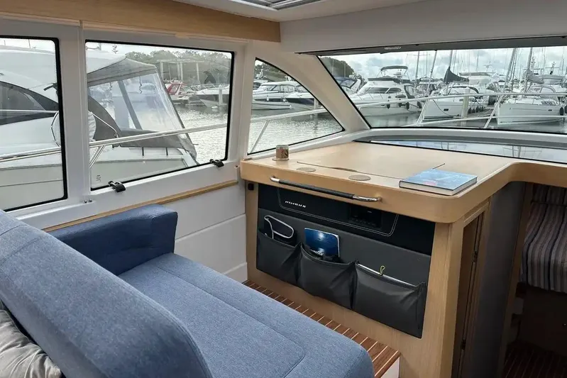 Bertie Yacht Photos Pics Interior of 2024 Nimbus 405 Coupé yacht with blue seating and marina view.