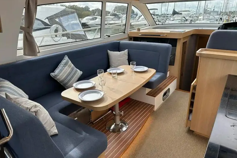 Bertie Yacht Photos Pics Interior of 2024 Nimbus 405 Coupé yacht with elegant dining area and panoramic windows.