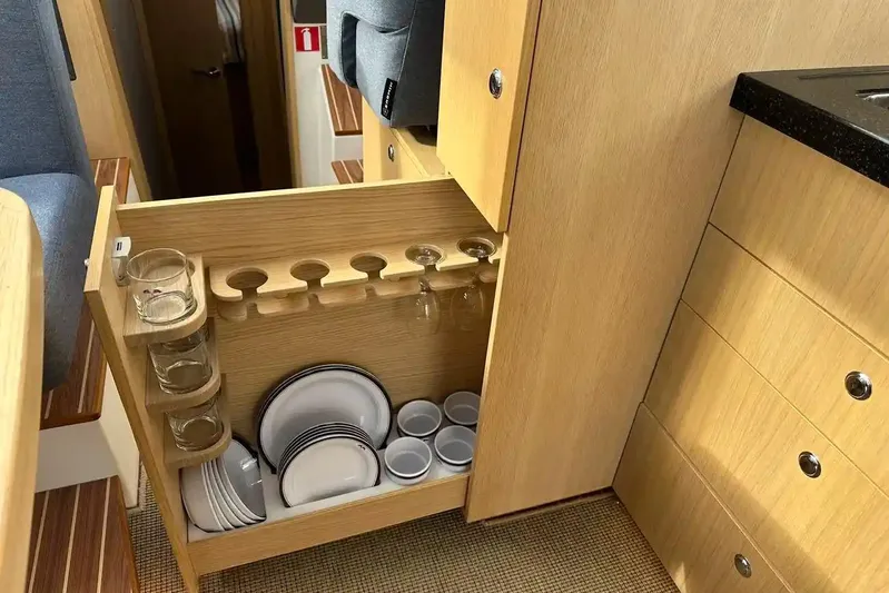 Bertie Yacht Photos Pics Interior of 2024 Nimbus 405 Coupé featuring organized kitchen storage with dishes and glasses.