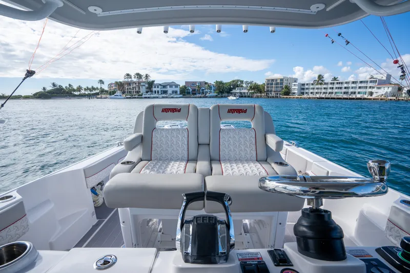 Patti Anne Yacht Photos Pics 2022 Intrepid 409 Valor boat interior with luxurious seating, ocean view, and coastal backdrop.
