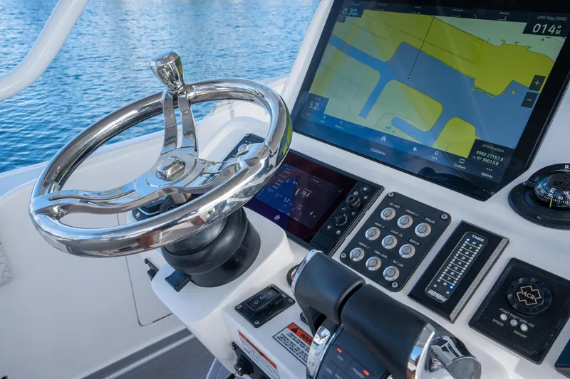 Patti Anne Yacht Photos Pics 2022 Intrepid 409 Valor helm with GPS display and controls, on calm blue water.
