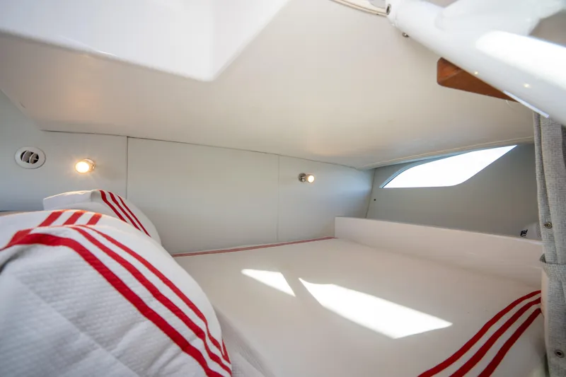 Patti Anne Yacht Photos Pics Cozy cabin interior of 2022 Intrepid 409 Valor with striped bedding and soft lighting.