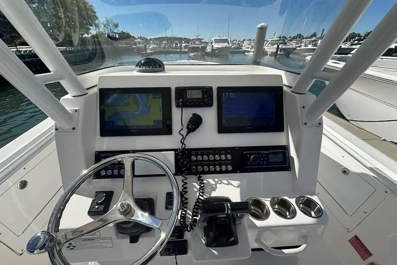  Yacht Photos Pics 2015 Edgewater 320CC boat dashboard with navigation screens and steering wheel in marina setting.