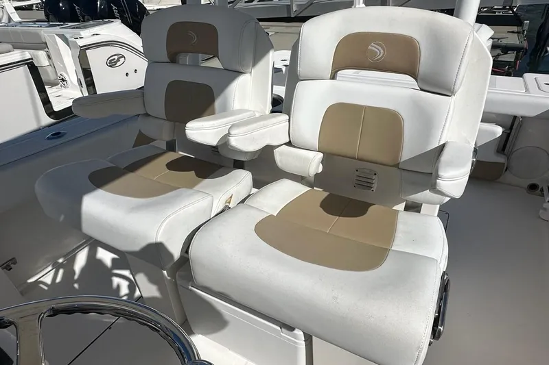  Yacht Photos Pics Two cushioned seats on a 2015 Edgewater 320CC boat, featuring armrests and beige accents.