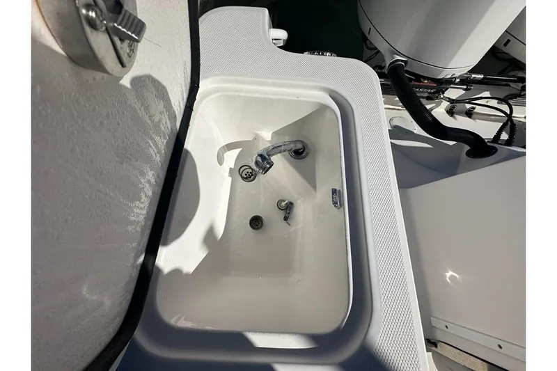  Yacht Photos Pics White sink on 2015 Edgewater 320CC boat, featuring faucet and drain.