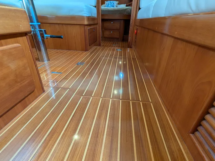 Ubiquitous Yacht Photos Pics Polished wooden interior of 2015 Outbound 46 yacht, featuring sleek flooring and cozy cabin space.