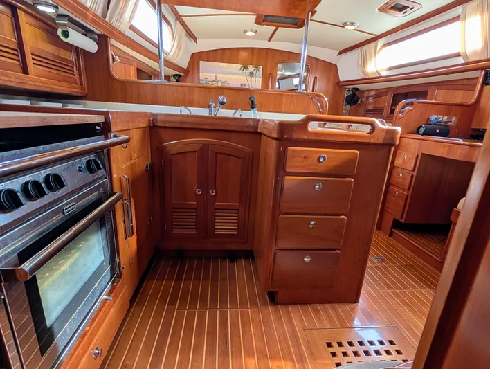 Ubiquitous Yacht Photos Pics Luxurious wooden interior of a 2015 Outbound 46 yacht kitchen with stove and cabinets.
