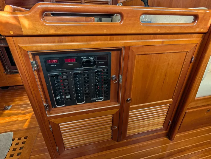 Ubiquitous Yacht Photos Pics Wooden electrical panel on 2015 Outbound 46 yacht, featuring switches and voltage display.