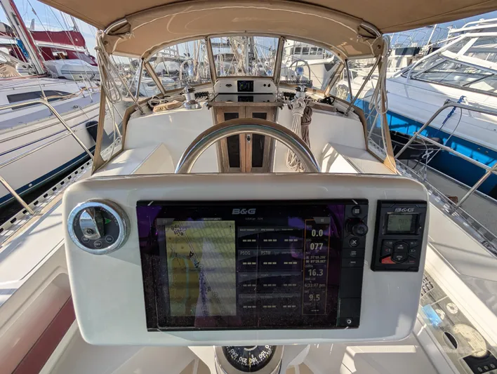 Ubiquitous Yacht Photos Pics Cockpit view of 2015 Outbound 46 sailboat with navigation equipment and steering wheel.