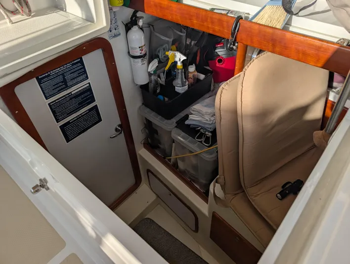 Ubiquitous Yacht Photos Pics Interior of 2015 Outbound 46 sailboat with storage, fire extinguisher, and cleaning supplies.
