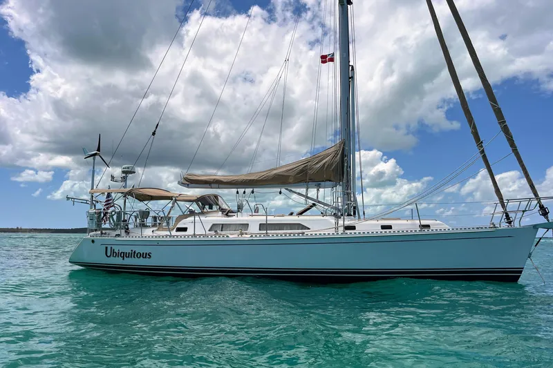 Ubiquitous Yacht Photos Pics Sailboat "Ubiquitous" on turquoise water, Outbound 46 model, 2015, under a cloudy sky.