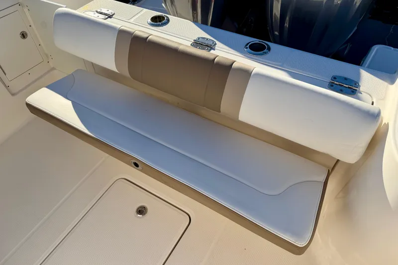 Da Kine Yacht Photos Pics 2022 Robalo R272 Center Console boat seating area with cushioned bench and storage.