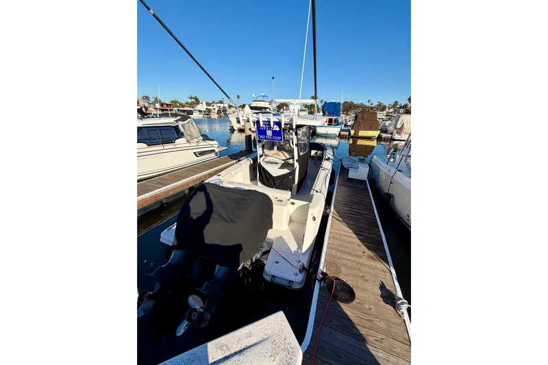 Da Kine Yacht Photos Pics 2022 Robalo R272 Center Console boat docked at marina under clear blue sky.