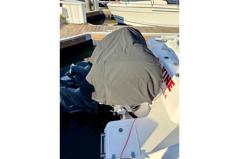 Da Kine Yacht Photos Pics 2022 Robalo R272 Center Console boat with covered outboard motor at dock.
