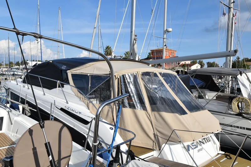 Vasanti Ll Yacht Photos Pics 2023 Azimut Atlantis 45 yacht docked in marina, featuring beige canopy and sleek design.