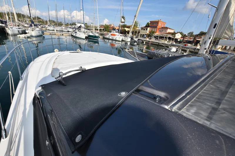 Vasanti Ll Yacht Photos Pics 2022 Azimut Atlantis 45 yacht docked in a marina, surrounded by sailboats.