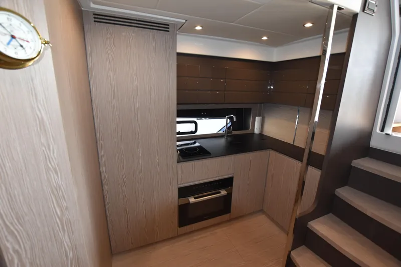 Vasanti Ll Yacht Photos Pics Modern kitchen interior of 2023 Azimut Atlantis 45 motor boat featuring sleek cabinetry and appliances.