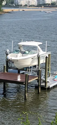  Yacht Photos Pics 2022 Sea Ray SLX 310 boat docked on a lift by the water.