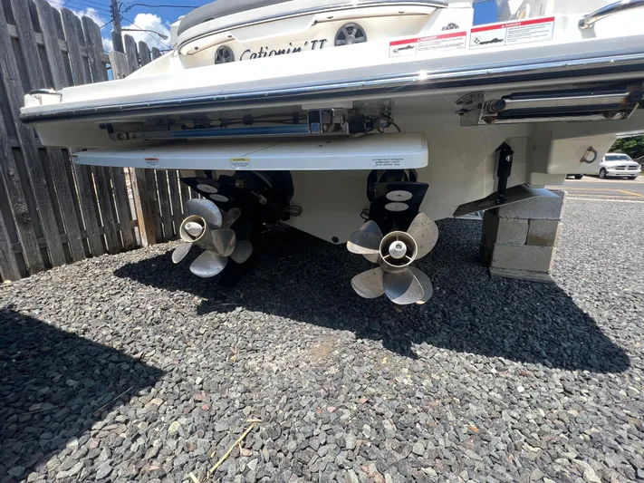  Yacht Photos Pics 2022 Sea Ray SLX 310 boat stern with dual propellers on gravel surface.