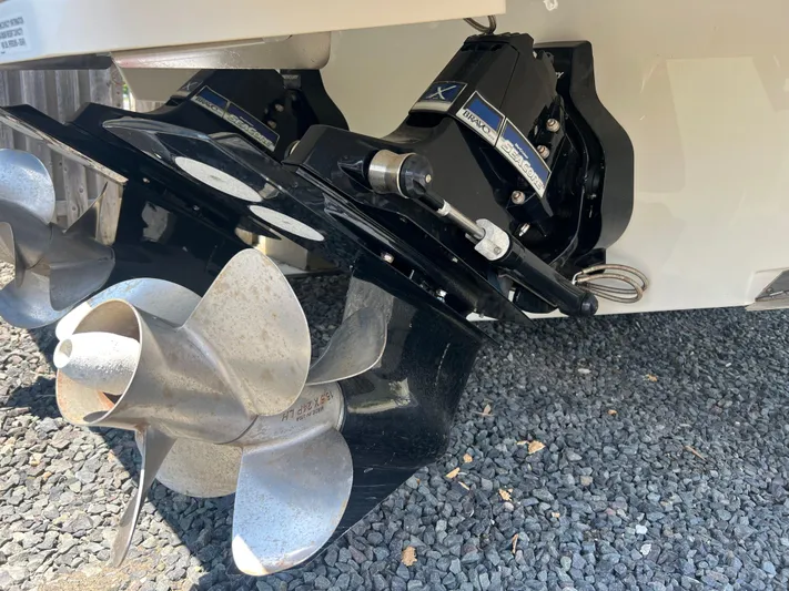  Yacht Photos Pics Close-up of 2022 Sea Ray SLX 310 boat propeller and outdrive on gravel.